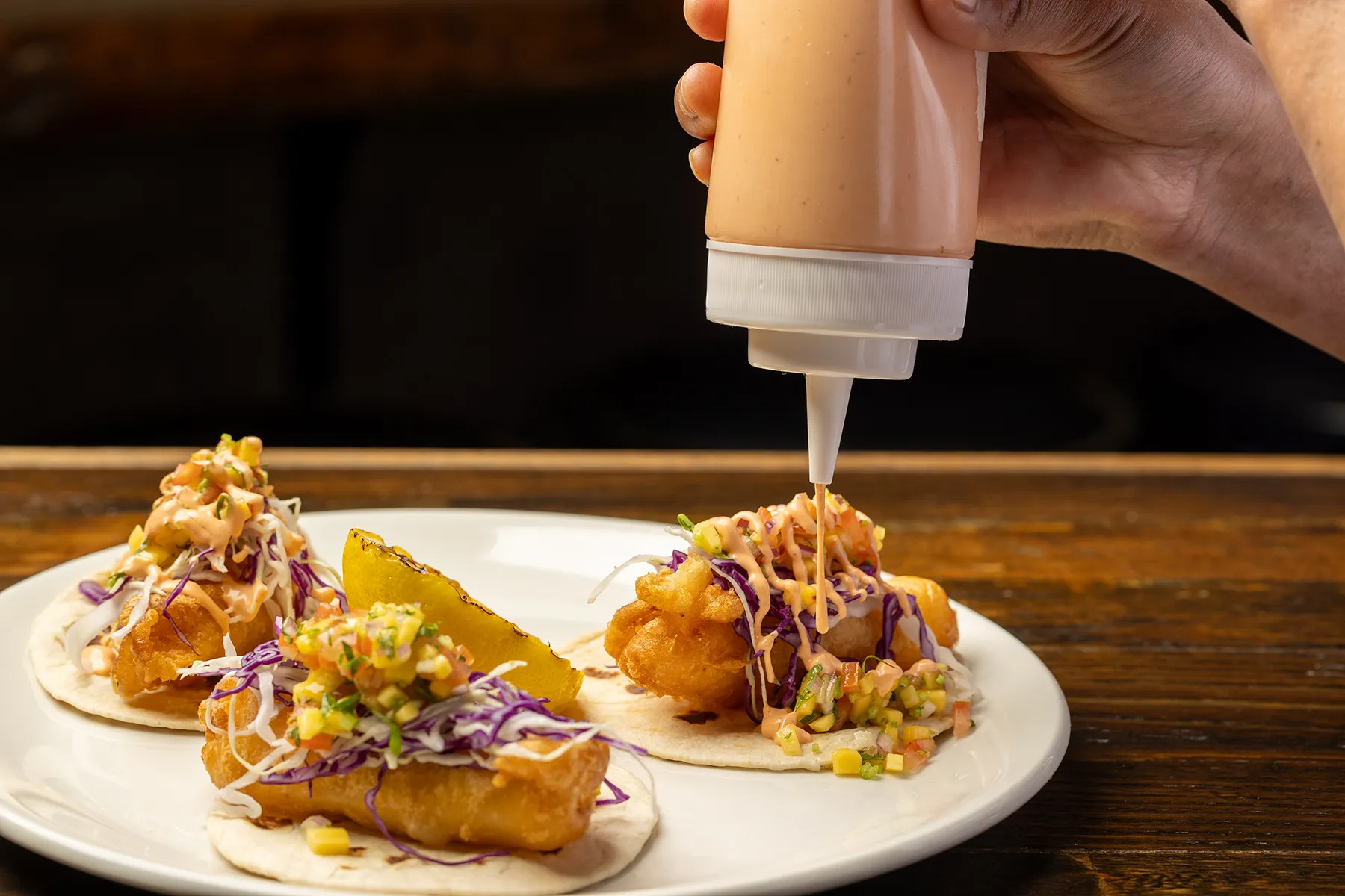 Beer-battered fish tacos topped with cabbage slaw and drizzled chipotle mayo.
