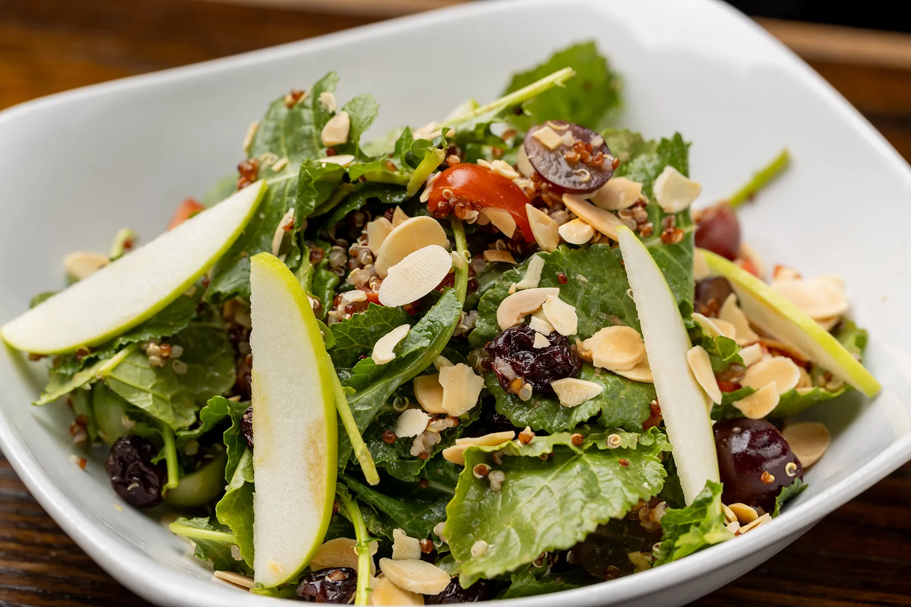 Kale and quinoa salad with pear slices, cranberries, and almonds.
