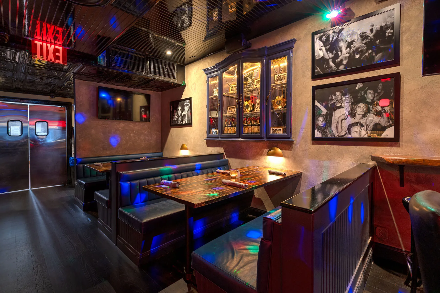 Intimate booth seating with wood tables and decorative photo wall.
