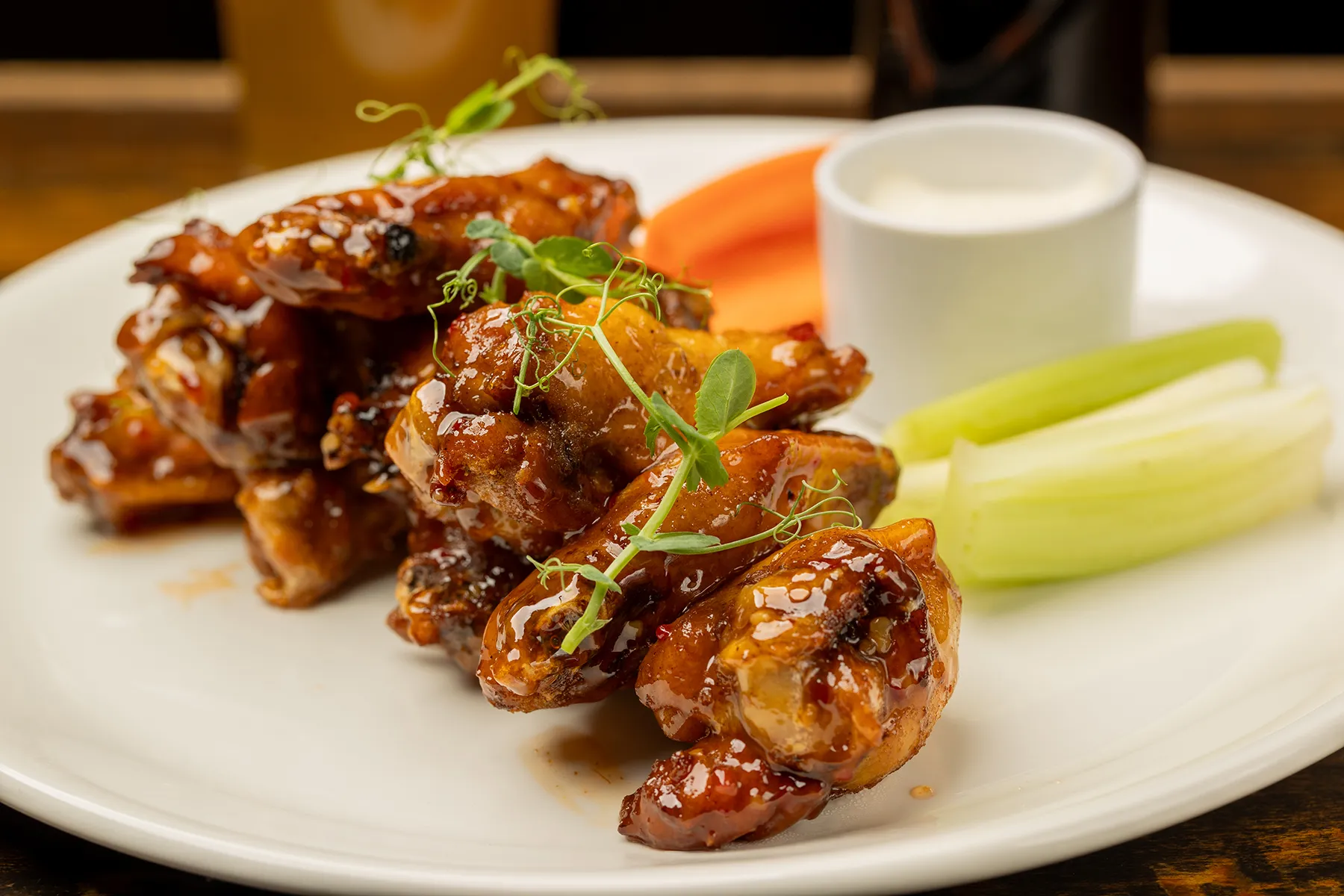 Glazed chicken wings with celery, carrots, and ranch dip.