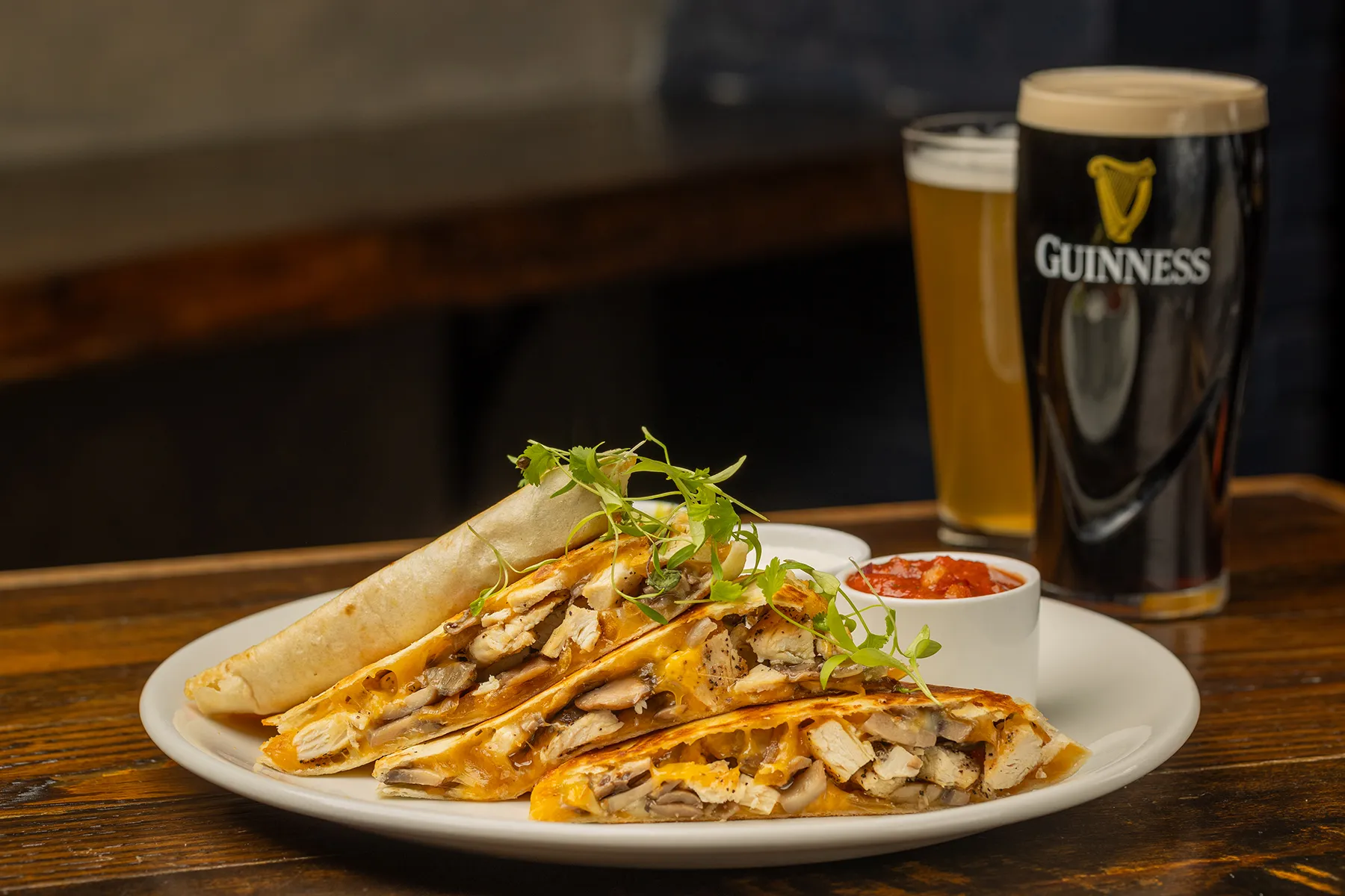 Chicken and cheese quesadillas with salsa and pints of beer.

